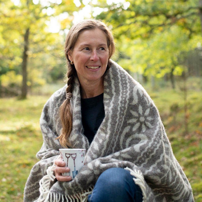 Hanna Lupiner i skogsbrynet med en ullfilt om axlarna
