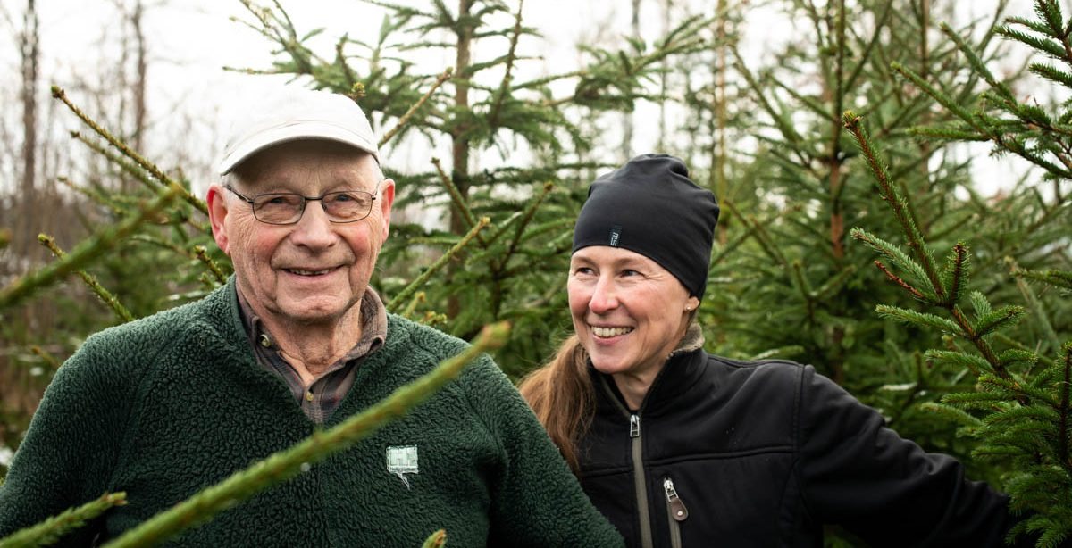 Uno och Hanna bland nyhuggna julgranar på gården